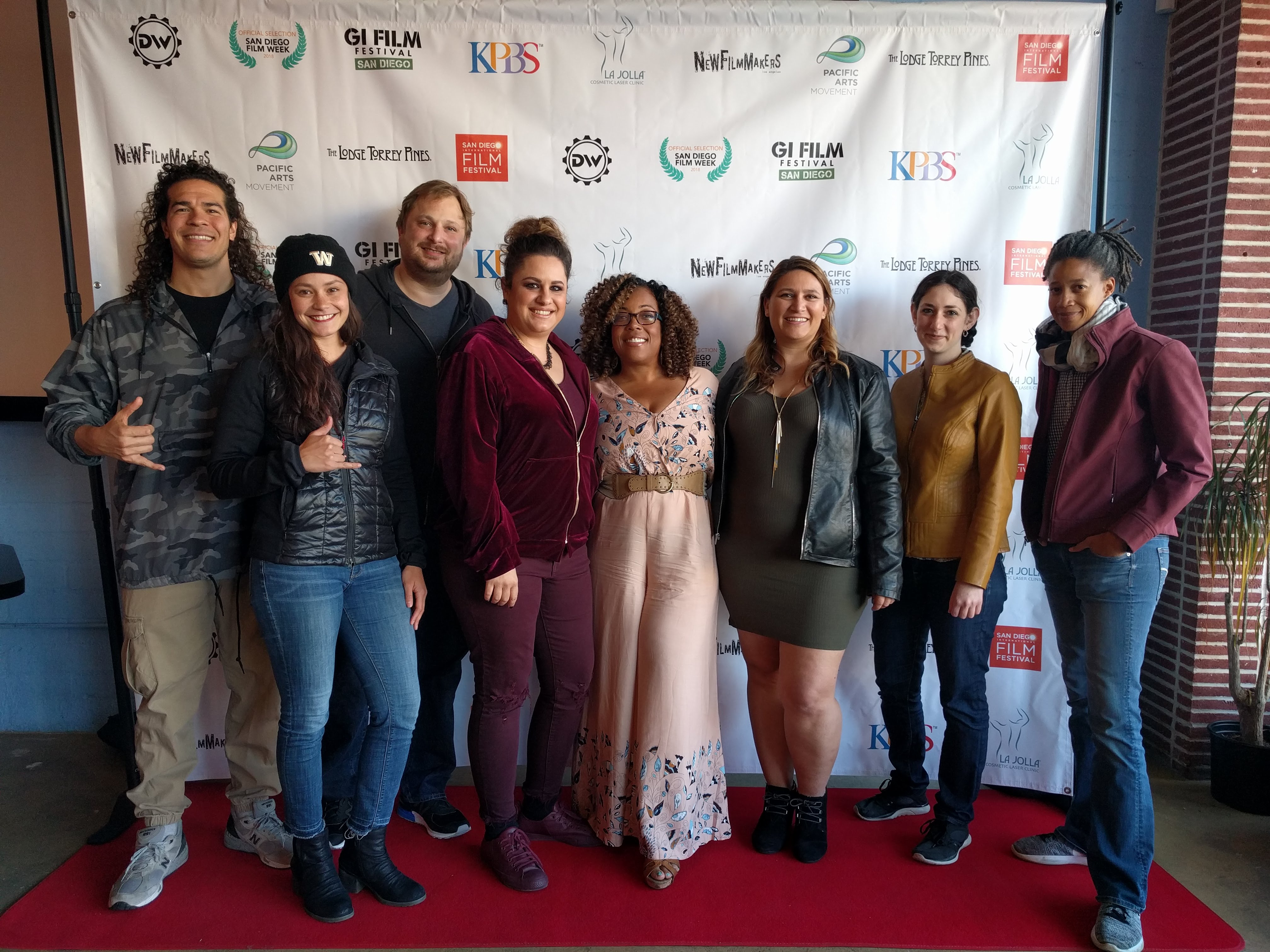 graduate students and faculty pose for photo on a red carpet for San Diego Film Week 2018