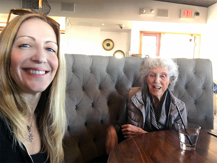 Associate Professor Kelly Gates sits smiling with Anita Schiller