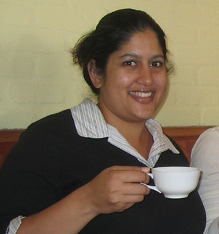Gayatri's profile photo of her holding a cup of coffee smiling